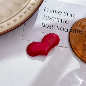 Detail view of heart-shaped red hair clip with golden Barrette La France lettering