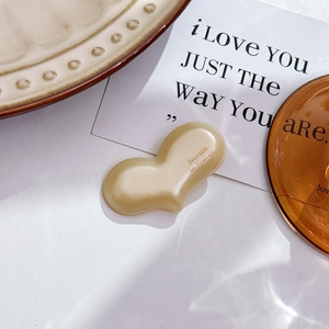 Macro detail of cream heart-shaped barrette with La France text in aesthetic setting