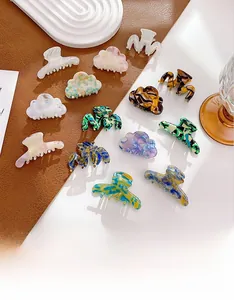 Détail de mini pinces à cheveux en acétate aux motifs marbrés et couleurs pastel