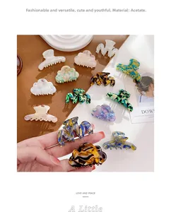 Détail de mini pinces à cheveux en acétate aux motifs marbrés et textures florales
