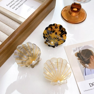 Elegant shell-shaped acetate hair claws with pearls in leopard, grey, and cream
