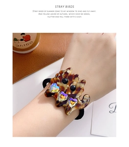 Close-up of heart-shaped rhinestones on tortoise shell pattern cat hair tie accessory