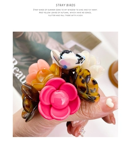 Detailed view of floral hair claws in acetate finish with diverse color patterns