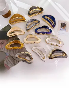 Détails à plat de grandes pinces à cheveux en acétate avec marbrures et cadres dorés