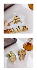 Detail of heart-shaped acetate claw clips with marble texture and gold alloy spring