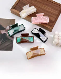 Detailed view of large square acetate hair claws with premium marble textures in various colors