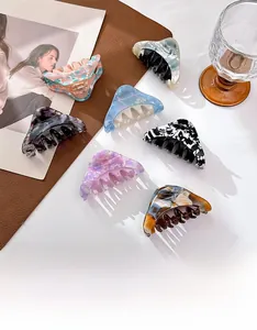 Detail of elegant acetate hair claws in various marble patterns and pastel colors