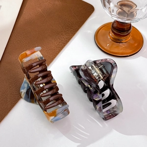 Elegant tortoiseshell hair claws with artistic marble patterns in brown and blue