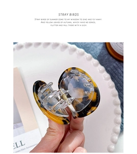 Close-up of tortoise shell pattern acetate cat-shaped hair clip with glossy finish