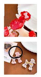 Détail de la pince à cheveux caniche rouge avec strass et élastique à cheveux rose
