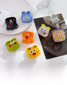 Mini pinces à cheveux en acétate motif monstre en sept couleurs sur un plateau