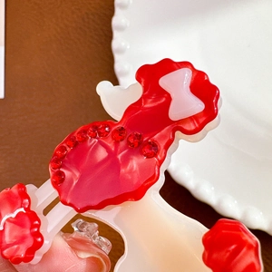 Pince à cheveux chic en acétate avec strass rouges et un petit nœud rose doux