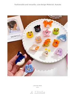 Détail de barrettes en acétate coloré aux formes d'animaux marins sur un plat en céramique