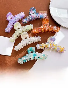 Detailed view of colorful floral hair claws with acetate petals and tiny faux pearl accents