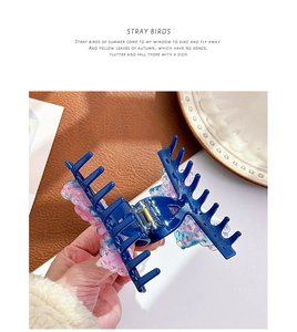 Macro view of blue acetate shark clip with colorful 3D resin floral details