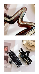 Vue macro détaillée de grandes pinces à cheveux ondulées avec des strass brillants incrustés