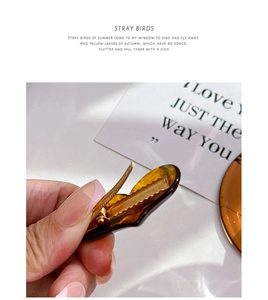 Detail view of tortoiseshell acetate hair clip with premium golden metal spring mechanism