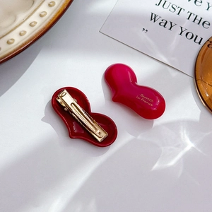Elegant heart-shaped acetate hair clip set with gold lettering and metal duckbill grip