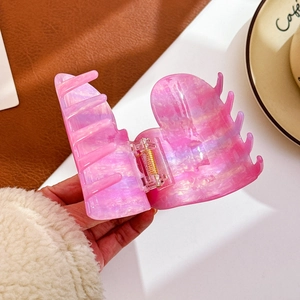 Pink purple marbled acetate heart hair claw clip with golden spring held by hand