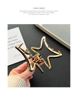 Detailed close-up of a vintage gold metal star-shaped hair claw with black resin inlay