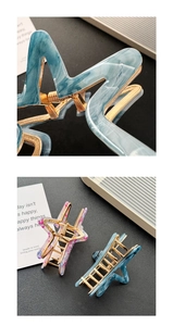 Close-up of star-shaped hair claws with blue marble and floral acetate textures