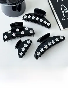 Detail view of premium black floral hair claws with elegant white flower accents