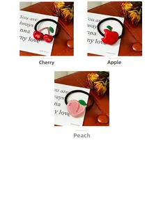 Detailed view of elastic hair ties featuring cherry, apple, and peach resin charms