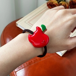 Red apple-shaped acetate hair tie with sparkling rhinestones and black elastic band