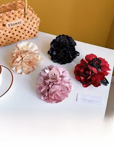 Detail von vier großen Blumen-Haarklammern in Schwarz, Champagner, Rosa und Burgunder