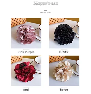 Detailansicht großer Blumen-Haarklammern in Pink, Schwarz, Rot und Beige mit Perlen