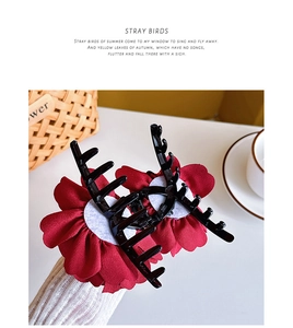 Detail einer großen roten Rosen-Haarklammer am Arm zeigt Blumendesign und Größe