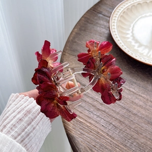 Handheld dark red camellia hair claw clip made of fabric flower and transparent plastic
