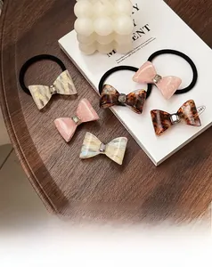 Detail of acetate bow hair clips and ties with crystals on a wooden background