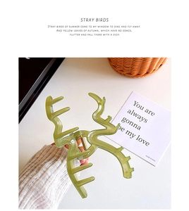 Close-up of matte matcha green wave-shaped hair claw clip on minimalist background