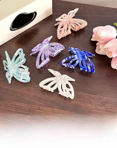 Vue détaillée de cinq pinces à cheveux papillon en acétate colorées sur bois