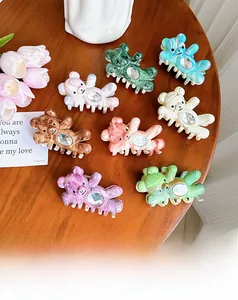 Detail of colorful bear hair claws with marble textures and crystal embellishments