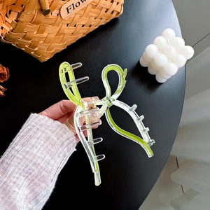 Large transparent bow hair claw clip with neon green ribbon detail for elegant updos