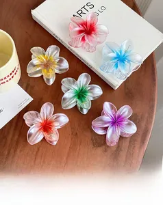 Detail of colorful gradient plumeria hair claws in six colors on a wooden table