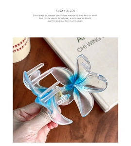 Close-up of blue and white gradient plumeria hair claw clip with transparent resin finish
