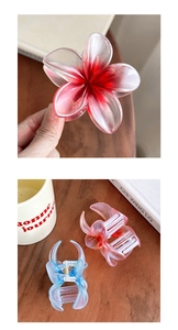 Macro detail of gradient resin plumeria hair claw clips with secure metal springs