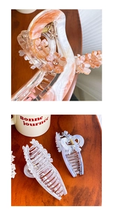 Détail d'une pince à cheveux effet marbre orange avec fleurs en cristal chic