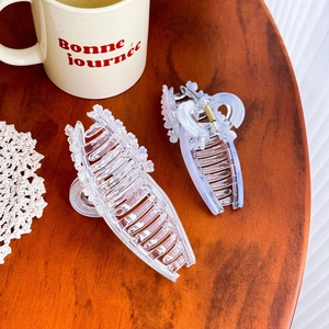 Ensemble élégant de pinces à cheveux transparentes et lilas sur table en bois