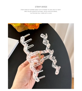 Close-up of large wavy acrylic hair claw clip with golden spring and transparent finish