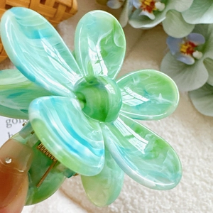 Pince à cheveux fleur en marbre vert et bleu avec une finition transparente