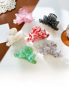 Collection of bow-shaped acetate claw clips in six elegant colors and marble patterns