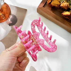 Pince à cheveux en acétate marbré rose avec ressort doré pour des coiffures élégantes