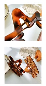 Détail macro de pinces à cheveux en résine écaille de tortue et ambre, design ondulé brillant