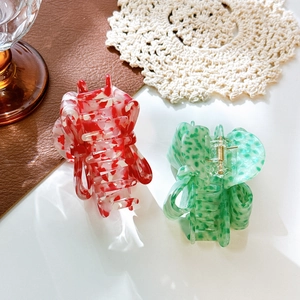 Elegant acetate bow hair claws in red marble and green speckled patterns for styling