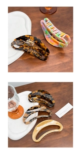 Detailed view of assorted acetate claw clips on a ceramic tray with a natural aesthetic