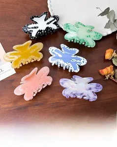 Set of six colorful butterfly hair claw clips in acetate finish on rustic wooden surface